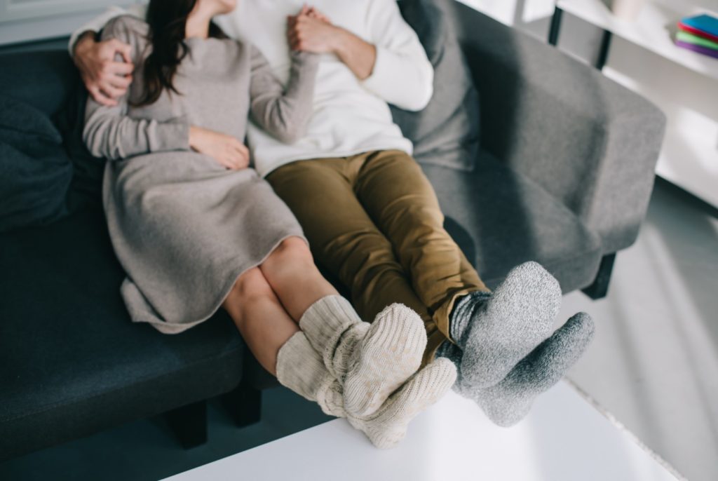 Two people on couch with socks on feet