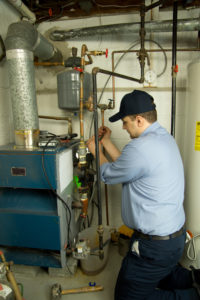 Tech repairing an HVAC system in Blaine, MN